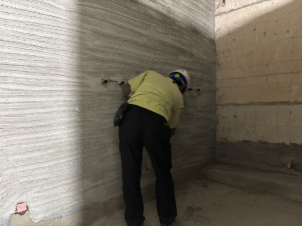 샤워실 벽면 상태 — 빗질 마감 미장과 수전 배관 돌출