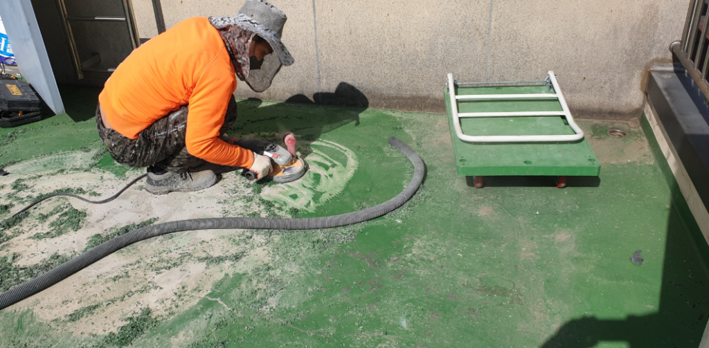 연삭기로 기존 우레탄을 철거하고 바닥면을 정리하는 모습