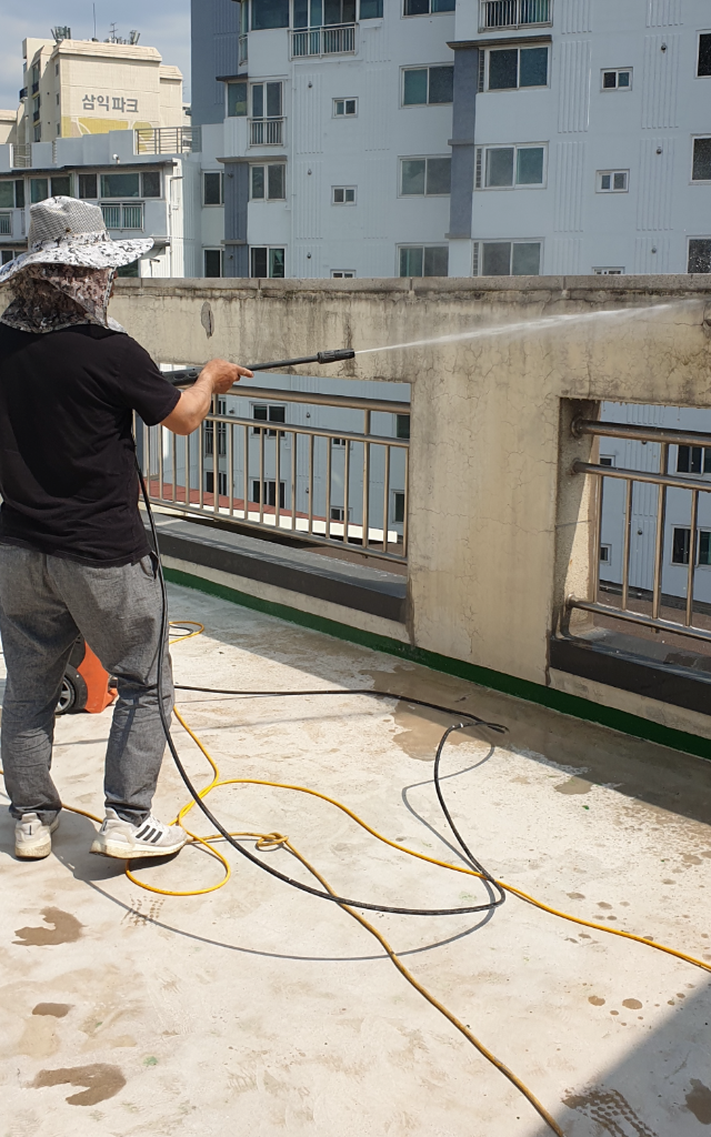 고압 물청소로 바탕면의 먼지와 이물질을 제거하는 모습