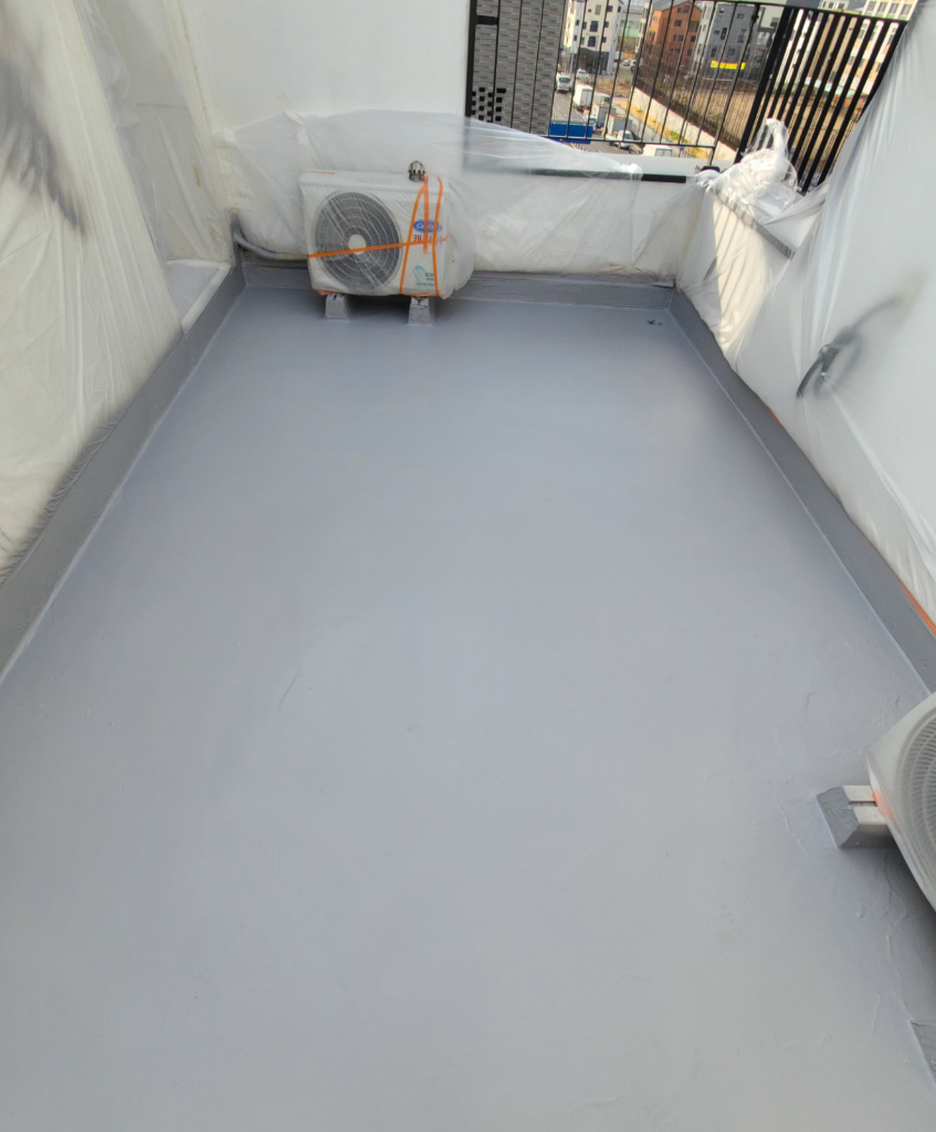 마감 완료 — 에어컨 실외기가 놓인 깔끔한 회색 바닥면