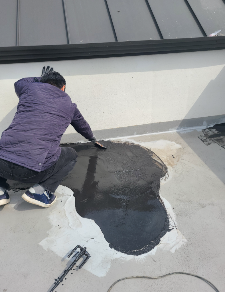 작업자가 중도 우레탄을 롤러로 도포하고 있는 장면