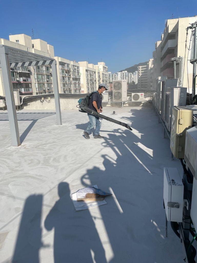 블로워로 옥상 바닥 먼지를 제거하는 작업 장면