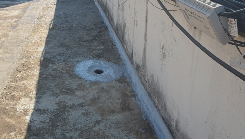 벽체와 바닥 코너, 우수관 접합부에 실란트가 시공된 클로즈업