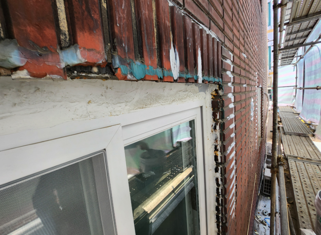 창틀 주변에 실란트를 시공하는 모습 — 갈라진 코킹을 제거하고 새 실란트로 충전