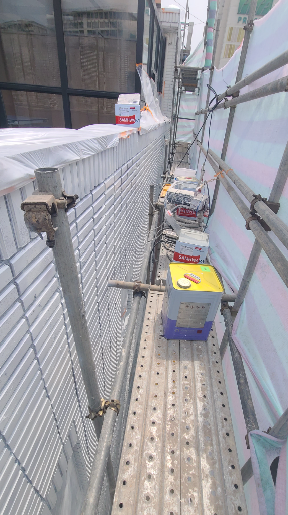 삼화페인트 에어리스 도장 장비와 자재가 아시바 위에 놓여 있는 모습