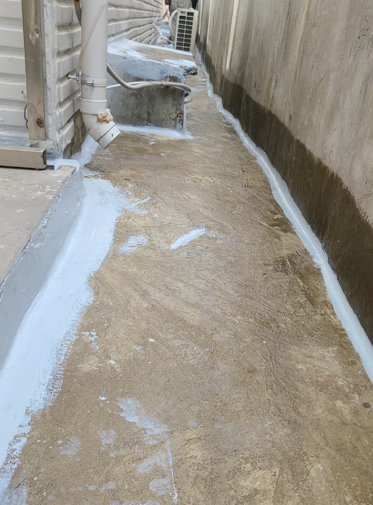1층 바닥 실란트 선처리 — 벽과 바닥이 만나는 접합부를 따라 흰색 실란트가 연속으로 시공된 상태, 바닥 중앙은 아직 콘크리트 그대로