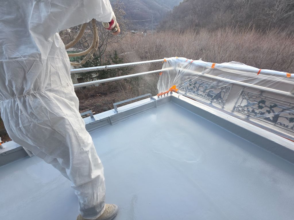 폴리우레아 스프레이 도포 중 — 회색 도막 형성